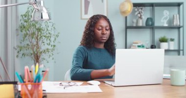 Ciddi ve güzel bir kadının portresi dizüstü bilgisayarını içeride otururken açar. Güzel Afrikalı Amerikalı öğrenci rahat bir odada bilgisayarda yazı yazıp arama yapıyor. Eğitim kavramı