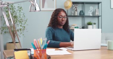 Odada otururken dizüstü bilgisayara başlayan mutlu Afro-Amerikan kız portresi. Güzel bir kız öğrenci içeride bilgisayar başında yazarken interneti araştırıyor. Eğitim kavramı