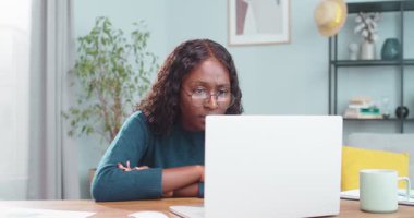 Hayal kırıklığına uğramış Afro-Amerikan güzel kıvırcık kız masada otururken dizüstü bilgisayara bakıyor. Bilgisayarda okuyan ve sonuçlardan memnun olmayan üzgün bir kız öğrencinin portresi. Duygular konsepti