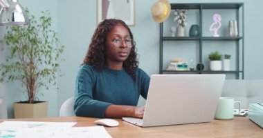 Gözlüklü, masasında oturan ve bilgisayarda yazan güzel, ciddi bir kız. Afro-Amerikan kadın portresi. Yorgun bir suratla bilgisayara mesaj atıp kapatıyor. Çalışma konsepti