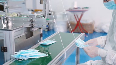Modern fabrikada yüz maskesi üretim hattı