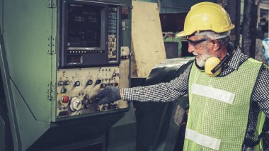 Fabrika atölyesinde makine kullanan akıllı bir fabrika işçisi