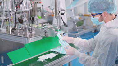 Modern fabrikada yüz maskesi üretim hattı