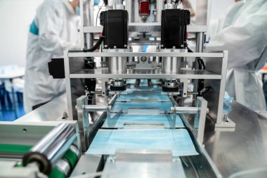 Modern fabrikada yüz maskesi üretim hattı