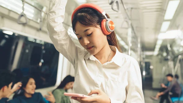 Jeune femme utilisant un téléphone portable dans le train public — Photo