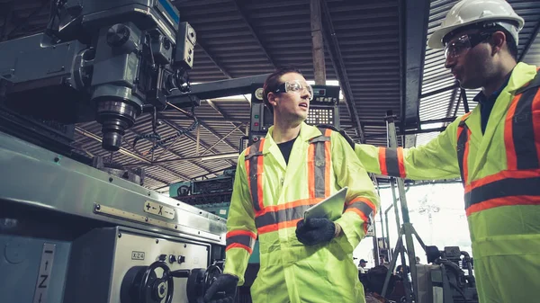 Factory worker warn coworker about safety and give hardhat to him