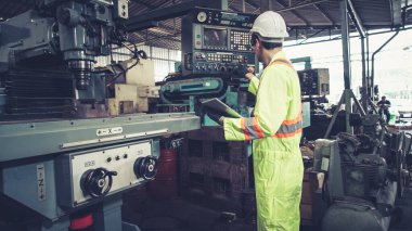 Fabrika atölyesinde makine kullanan akıllı bir fabrika işçisi