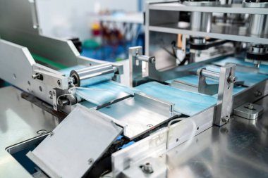 Modern fabrikada yüz maskesi üretim hattı