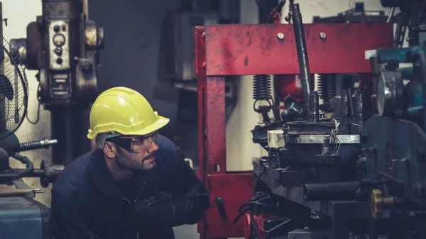 Fabrika işçisi, makine parçalarını incelerken taşınabilir radyodan konuşuyor. — Stok fotoğraf