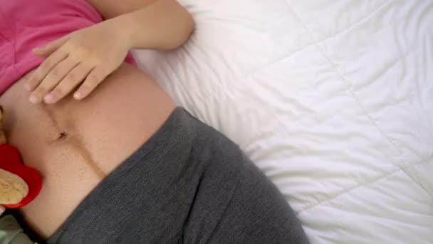 Щаслива вагітна жінка спить на ліжку в спальні . — стокове відео