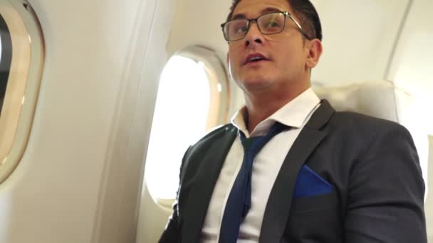 Empresário tem suco de laranja servido por uma aeromoça em avião — Vídeo de Stock