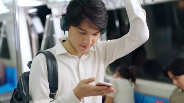 Biznesmen korzystający z telefonu komórkowego w pociągu publicznym — Wideo stockowe