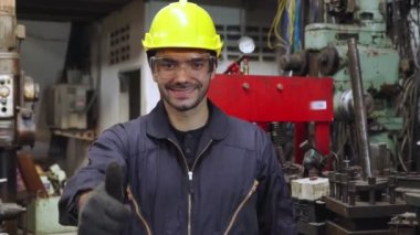 Genç bir fabrika işçisi ya da mühendis fabrikada portreyi kapatıyor.