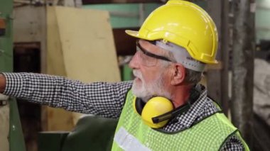 Fabrika işçisi fabrika atölyesinde makine teçhizatı kullanmayı öğretiyor.