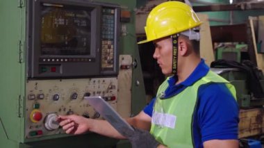 Fabrika atölyesinde makine kullanan akıllı bir fabrika işçisi