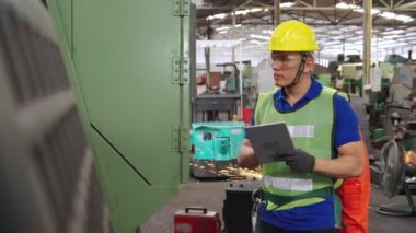 Fabrika atölyesinde makine kullanan akıllı bir fabrika işçisi