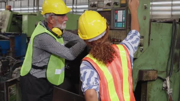 Groep fabrieksarbeiders die machineapparatuur gebruiken in fabriekswerkplaats — Stockvideo