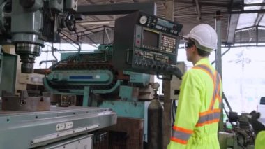 Fabrika atölyesinde makine ekipmanı kullanan bir grup işçi.