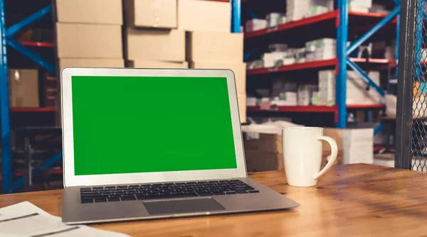 Computer with green screen display in warehouse storage room