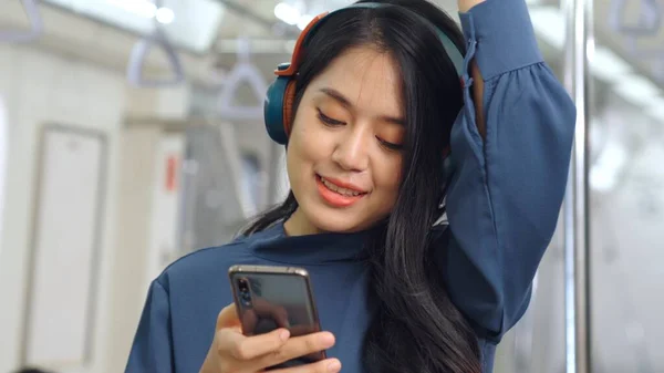Jeune femme utilisant un téléphone portable dans le train public — Photo