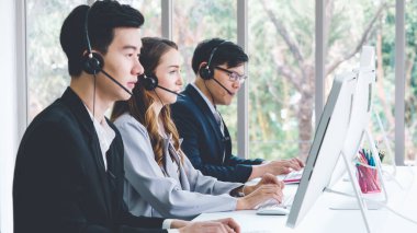 Ofiste çalışan kulaklık takan iş adamları.