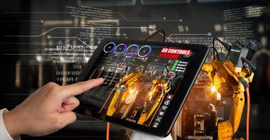 Mühendis, artırılmış gerçeklik endüstrisi teknolojisiyle robotik kolları kontrol ediyor.