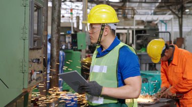 Fabrika atölyesinde makine kullanan akıllı bir fabrika işçisi