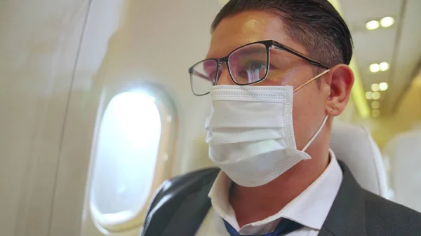 Reisender trägt Gesichtsmaske während der Reise im Verkehrsflugzeug . — Stockfoto