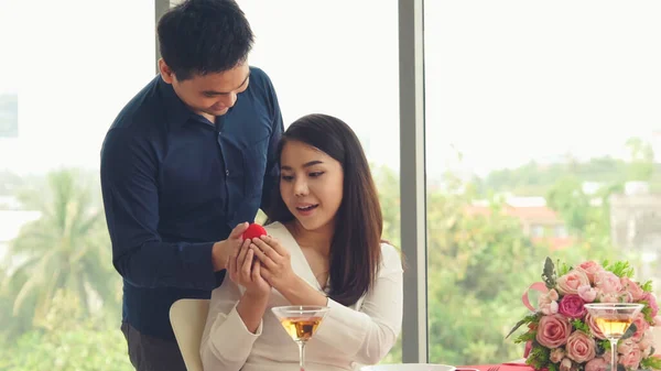 Romantic couple giving gift to lover at restaurant — Stock Photo, Image