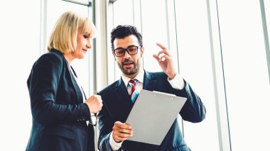 İki iş adamı ofiste proje stratejisi hakkında konuşuyor