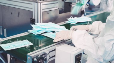 Modern fabrikada yüz maskesi üretim hattı