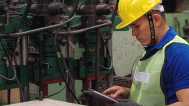 Fabrika atölyesinde makine kullanan akıllı bir fabrika işçisi