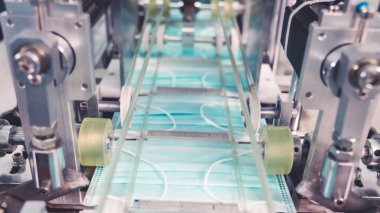 Modern fabrikada yüz maskesi üretim hattı