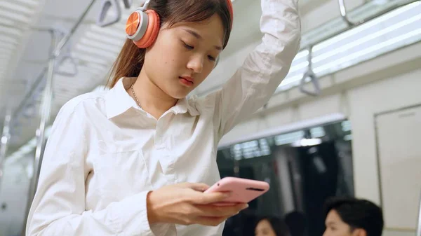 Jeune femme utilisant un téléphone portable dans le train public — Photo