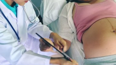 Hastanede hamile kadın ve jinekolog.