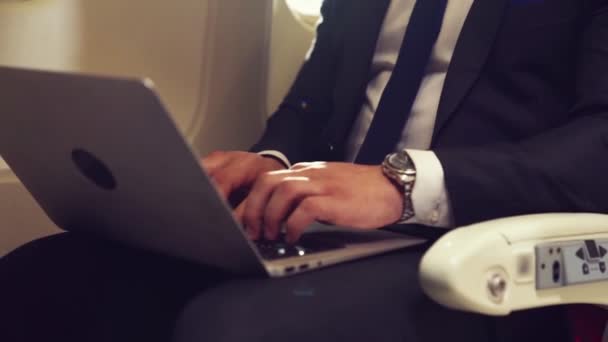 Joven hombre de negocios usando computadora portátil en avión — Vídeos de Stock