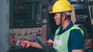 Fabrika atölyesinde makine kullanan akıllı bir fabrika işçisi