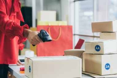 Çevrimiçi satıcı ev ofisinde çalışıyor ve teslimat kutusunu müşteriye paketliyor..