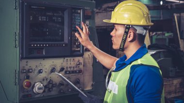 Fabrika atölyesinde makine kullanan akıllı bir fabrika işçisi