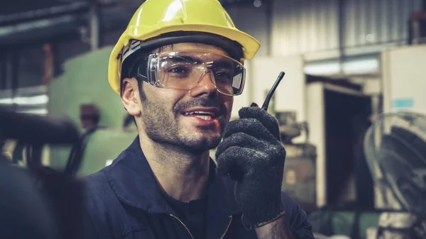 Operaio che parla alla radio portatile mentre ispeziona le parti di macchine — Foto Stock