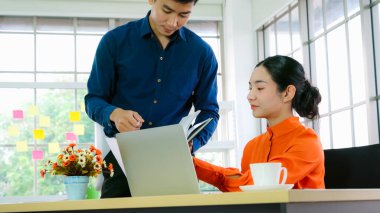 İki iş adamı ofiste proje stratejisi hakkında konuşuyor