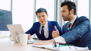 İki iş adamı ofiste proje stratejisi hakkında konuşuyor