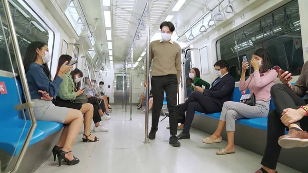 Dav lidí v masce obličeje na přeplněné veřejné metro cestování vlakem — Stock fotografie