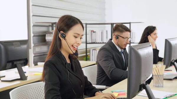 Uomini d'affari che indossano cuffie che lavorano in ufficio — Foto Stock