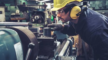 Fabrika atölyesinde makine kullanan akıllı bir fabrika işçisi