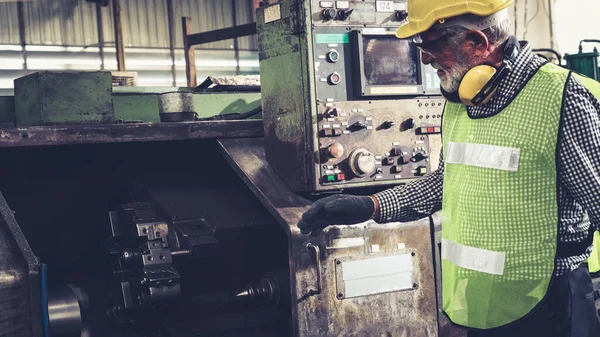 Fabrika atölyesinde makine kullanan akıllı bir fabrika işçisi