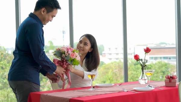 Romantic couple giving gift to lover at restaurant — Stock Photo, Image