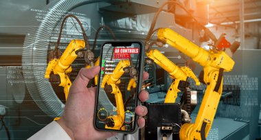 Mühendis, artırılmış gerçeklik endüstrisi teknolojisiyle robotik kolları kontrol ediyor.