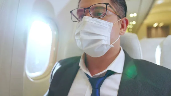 Мандрівник у масці для обличчя під час подорожі на комерційному літаку  . — стокове фото