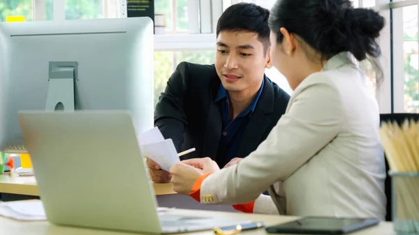 Two business people talk project strategy at office